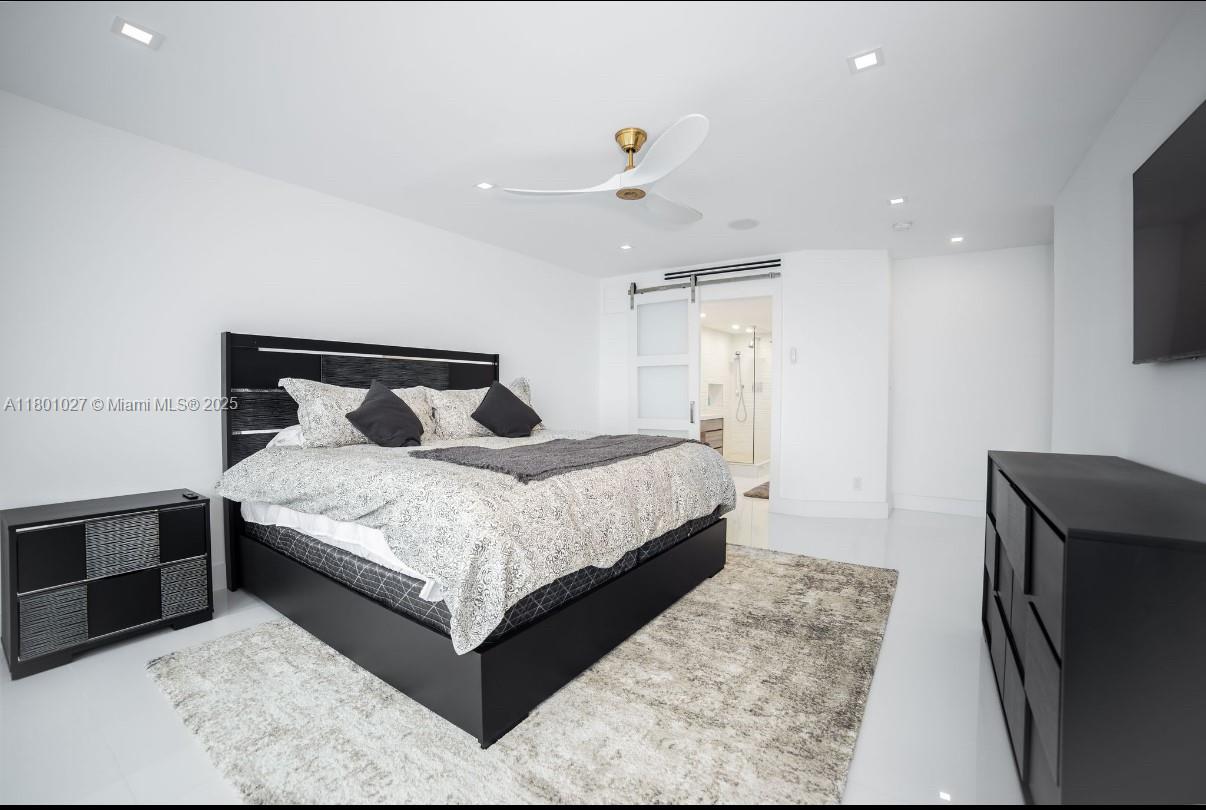 5600 Collins Avenue, Unit 14K Miami Beach, FL 33140 - Photo 8 of 27 a bedroom with a bed and a flat screen tv