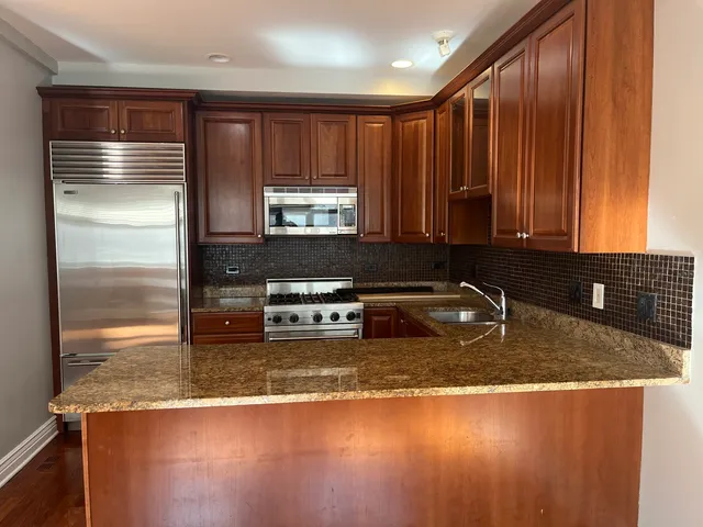 a kitchen with a refrigerator a stove a sink and a window