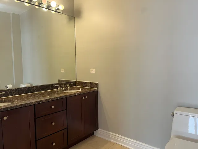 a bathroom with a granite countertop sink and a mirror