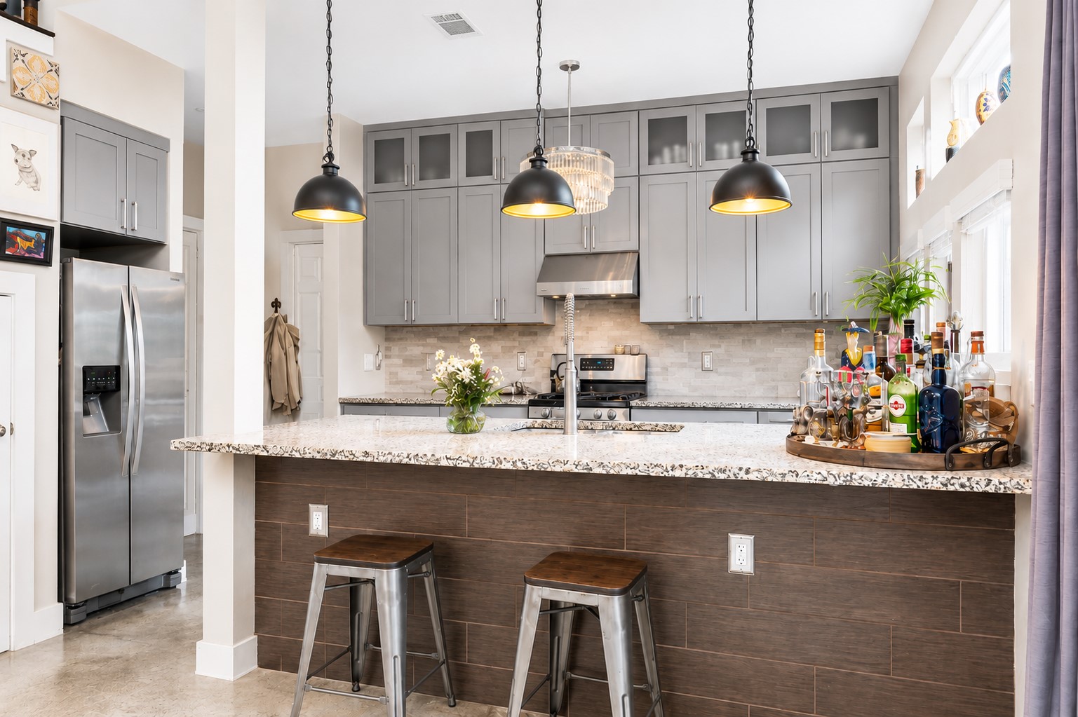 1800 Webberville Road, Unit B Austin, TX 78721 - Photo 10 of 30 Kitchen island featuring a speckled countertop, brown wood-look paneling, and pendant lighting