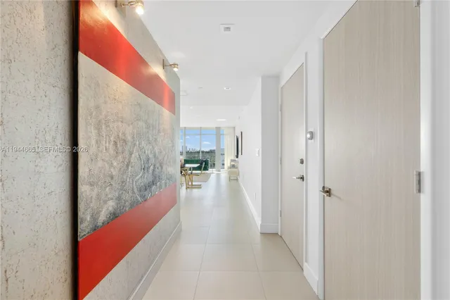 a hallway with a large window and kitchen view