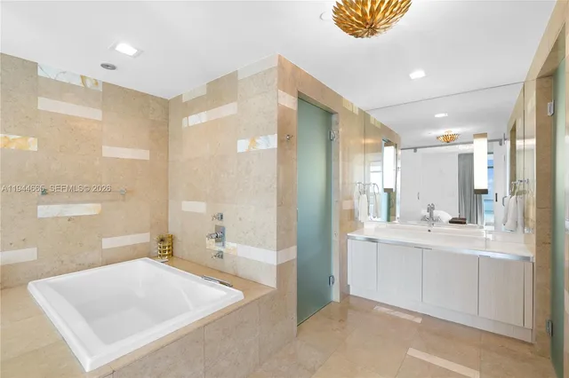 a bathroom with a tub sink and mirror