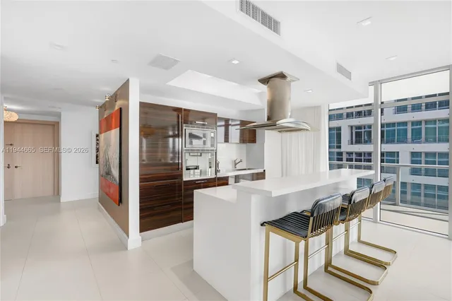 a open kitchen with stainless steel appliances kitchen island a refrigerator and a dining table