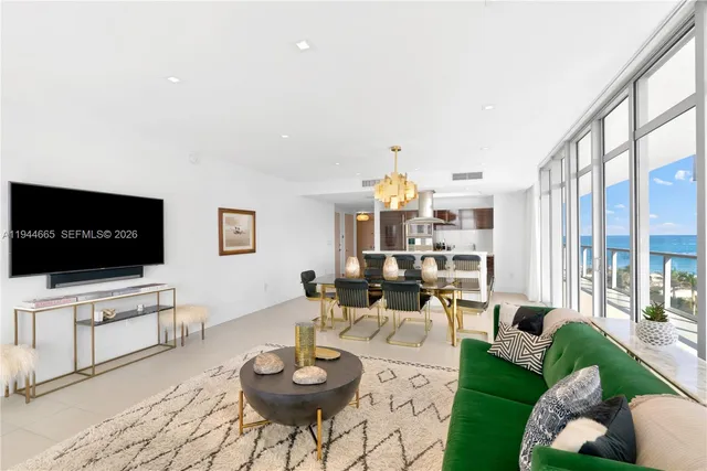 a living room with furniture a flat screen tv and a large window