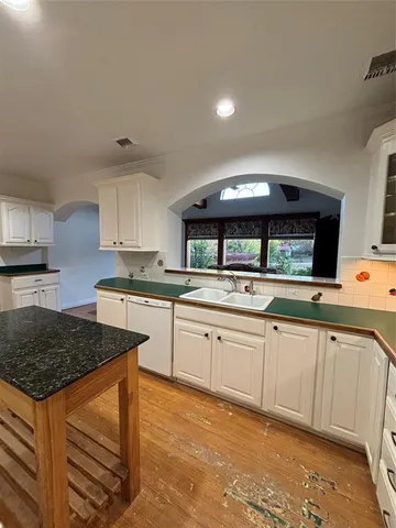 a kitchen with granite countertop a sink stainless steel appliances and cabinets