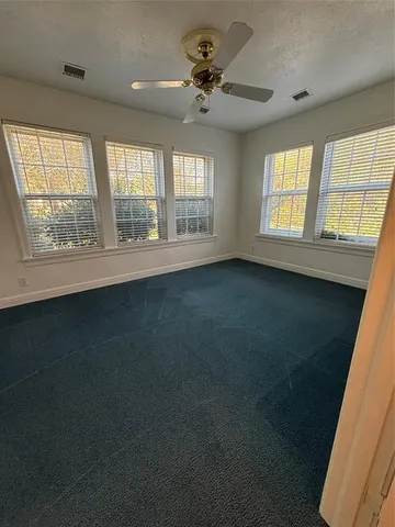 a kitchen with stainless steel appliances kitchen island granite countertop a stove top oven a sink dishwasher a refrigerator and white cabinets with wooden floor