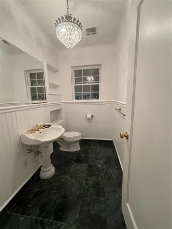 a bathroom with a sink toilet a mirror and window