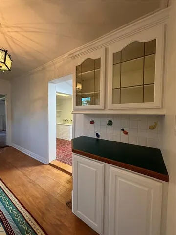 a kitchen with stainless steel appliances kitchen island granite countertop white cabinets and wooden floors
