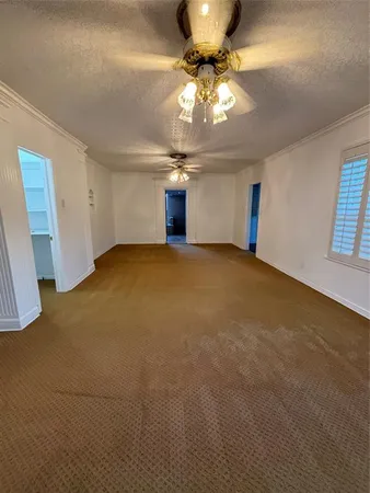 a view of an empty room with a chandelier fan