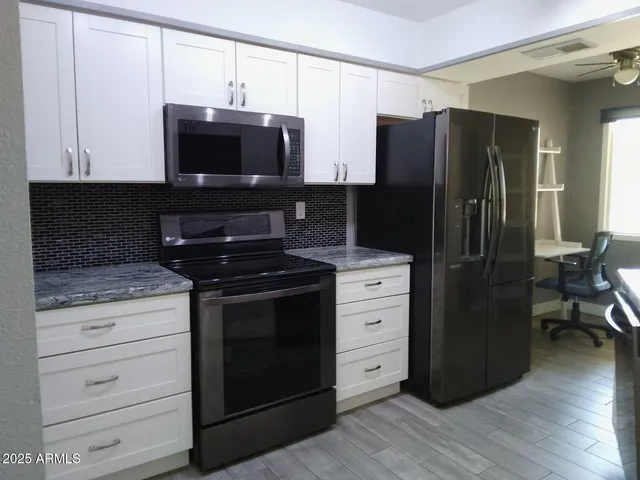 a kitchen with stainless steel appliances granite countertop a refrigerator and a sink