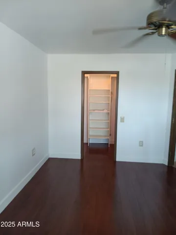 an empty room with wooden floor and closet
