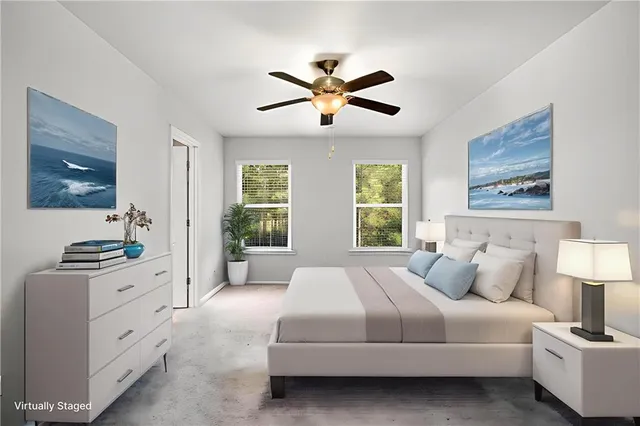 a bedroom with a large bed and a chandelier fan