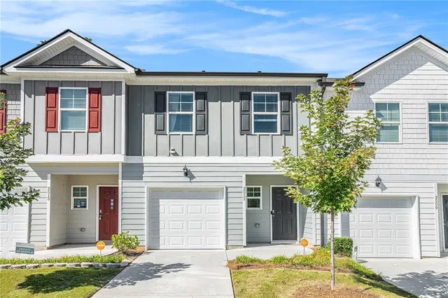 a front view of a house with a yard and garage