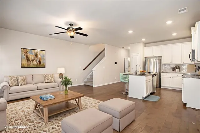 a living room with furniture and kitchen view