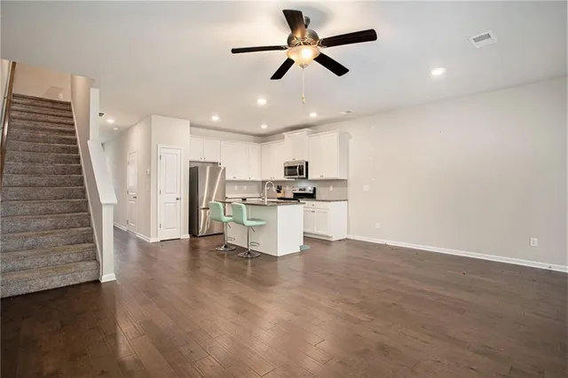 a view of kitchen with stainless steel appliances a refrigerator oven a stove top oven with wooden floor