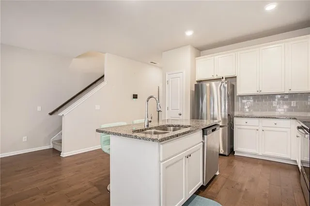 a kitchen with stainless steel appliances granite countertop a sink stove and refrigerator