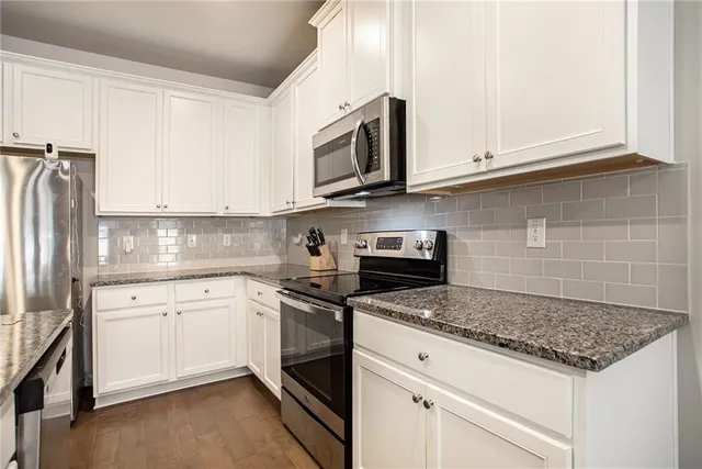 a kitchen with stainless steel appliances granite countertop a sink stove and microwave