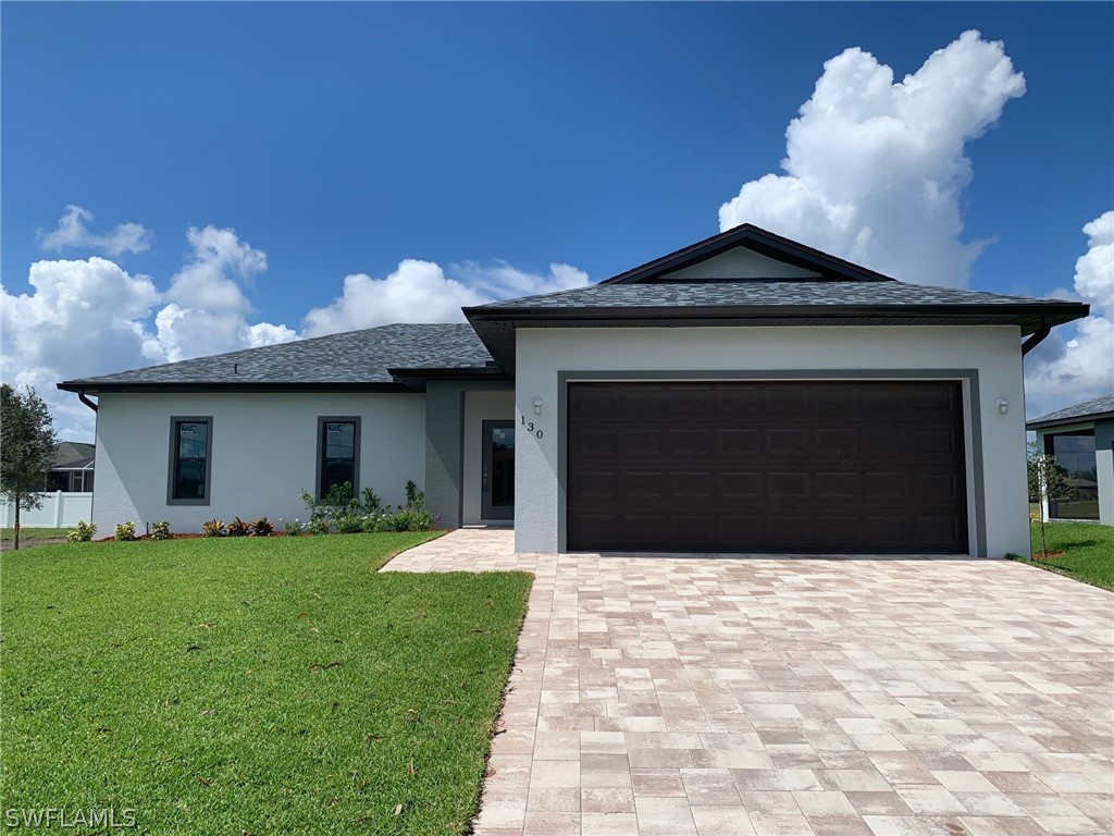 130 Southwest 37th Avenue Cape Coral, FL 33991 - Photo 1 of 30 a front view of a house with a yard and garage