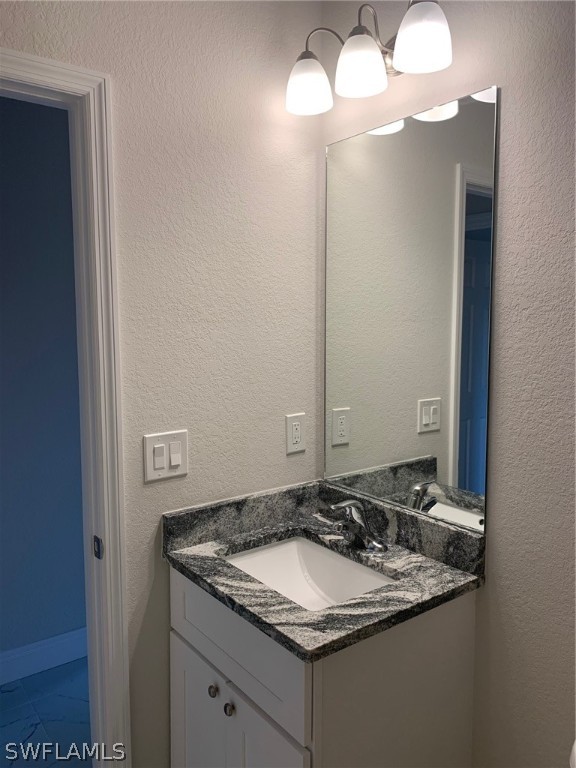 130 Southwest 37th Avenue Cape Coral, FL 33991 - Photo 16 of 30 a bathroom with a granite countertop sink and a mirror