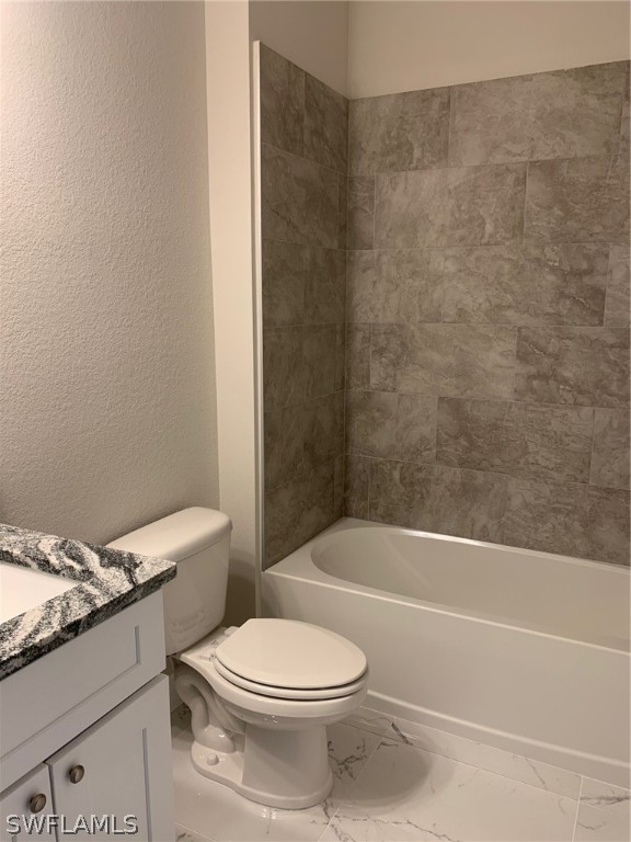130 Southwest 37th Avenue Cape Coral, FL 33991 - Photo 17 of 30 a white toilet and tub sitting next to a bathroom sink