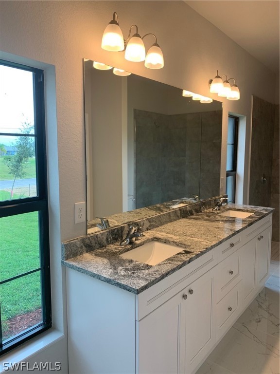 130 Southwest 37th Avenue Cape Coral, FL 33991 - Photo 23 of 30 a bathroom with a granite countertop sink and a large mirror