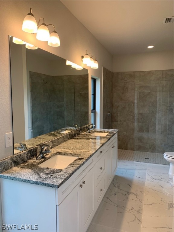 130 Southwest 37th Avenue Cape Coral, FL 33991 - Photo 24 of 30 a bathroom with a granite countertop sink a toilet a mirror and shower