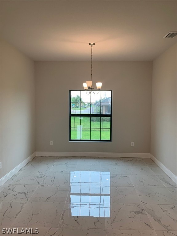 130 Southwest 37th Avenue Cape Coral, FL 33991 - Photo 10 of 30 an empty room with windows and chandelier