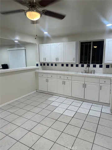 a large white kitchen with a sink and cabinets
