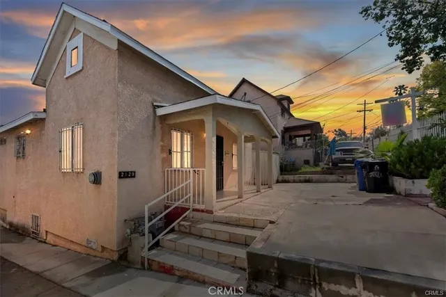 a view of a house with a small yard and furniture