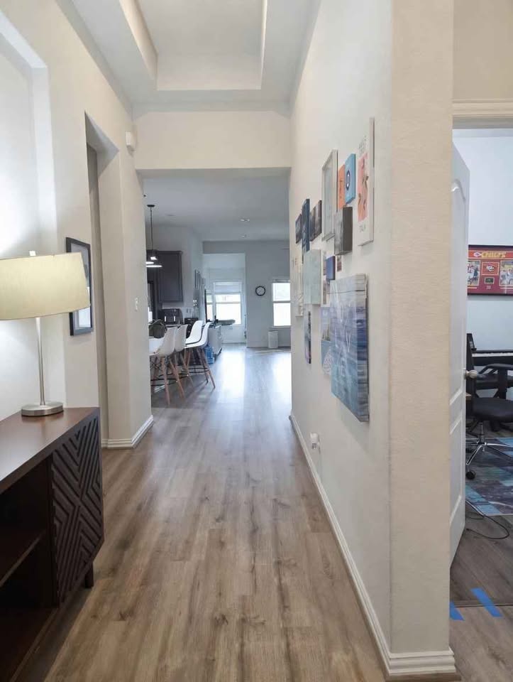 4105 Gildas Path Pflugerville, TX 78660 - Photo 5 of 15 A well-lit hallway with light wood flooring creates an inviting passage to adjacent living spaces.