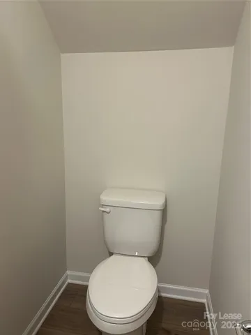 a white toilet sitting next to a white wall