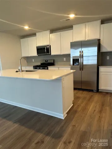 a kitchen with stainless steel appliances a refrigerator sink and microwave
