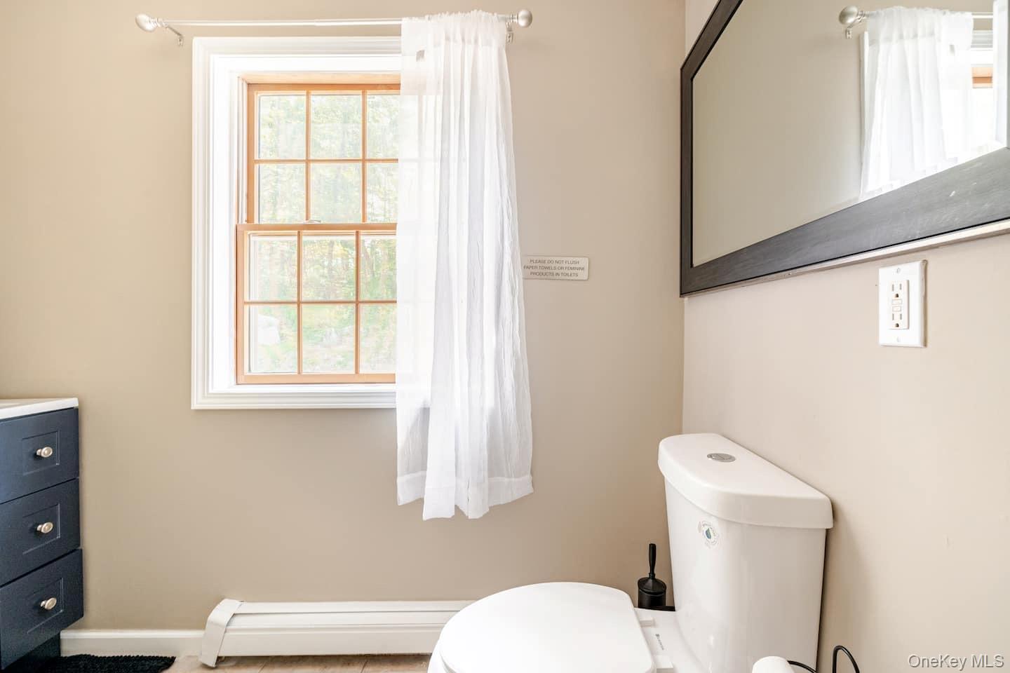 1241 Ridgebury Road New Hampton, NY 10958 - Photo 16 of 21 a white toilet sitting next to a bathroom sink