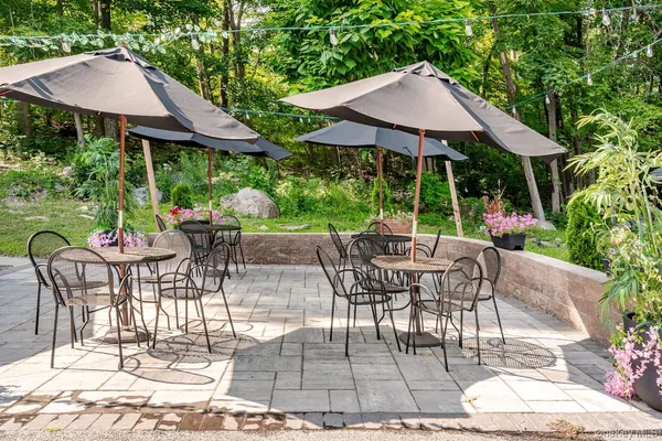 a view of patio with table and chairs under an umbrella
