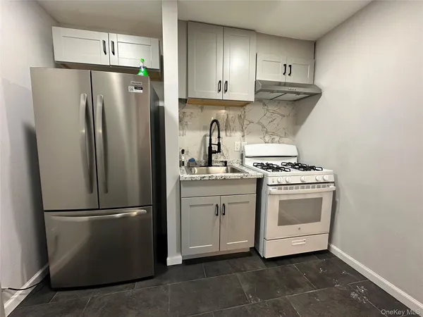 a kitchen with a refrigerator sink and cabinets