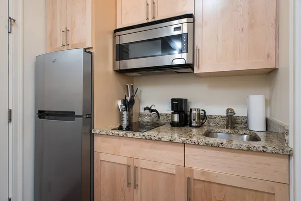 a kitchen with granite countertop white cabinets and a stainless steel appliances