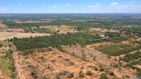 an aerial view of residential houses with outdoor space and trees