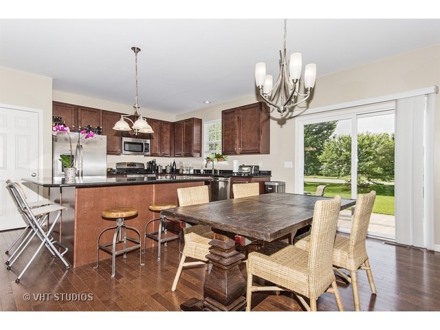 3153 Riley Road Montgomery, IL 60538 - Photo 5 of 15 a view of a dining room with furniture a chandelier and large windows
