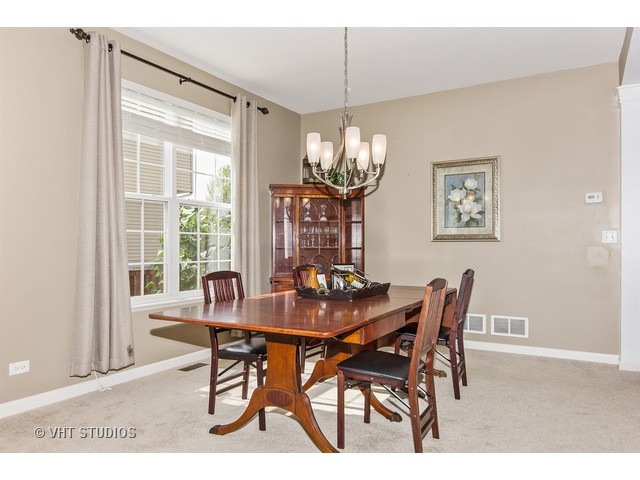 3153 Riley Road Montgomery, IL 60538 - Photo 6 of 15 a dining room with furniture a chandelier and wooden floor