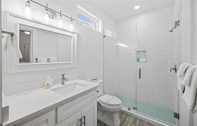 a bathroom with a sink a toilet and shower