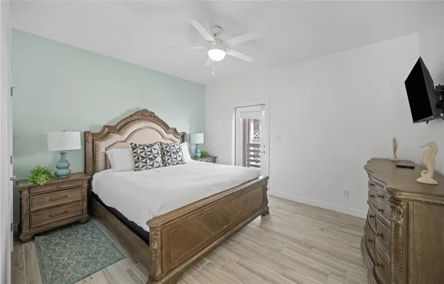 a bedroom with a bed a flat screen tv and dresser