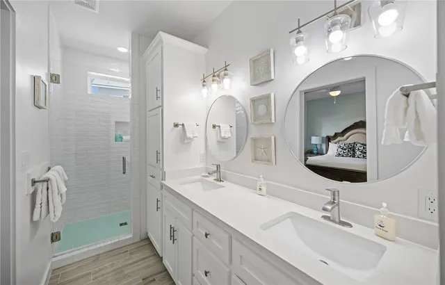 a bathroom with a double vanity sink mirror and shower