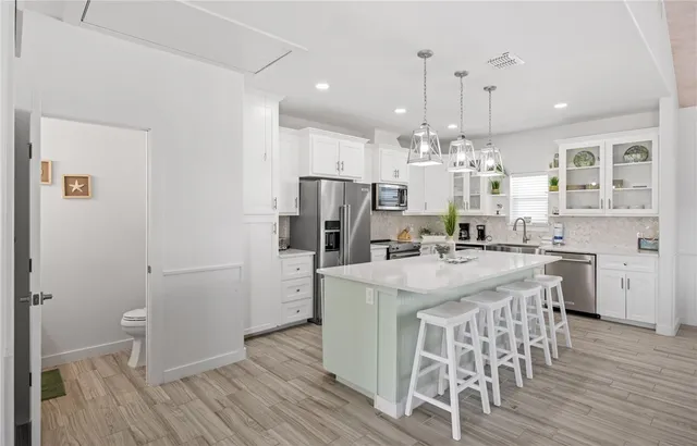a kitchen with stainless steel appliances kitchen island granite countertop a refrigerator and a stove top oven