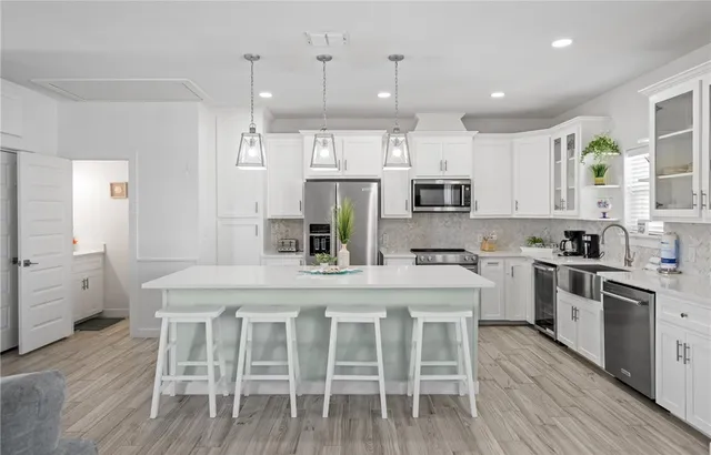 a kitchen with stainless steel appliances granite countertop a table chairs stove microwave and cabinets