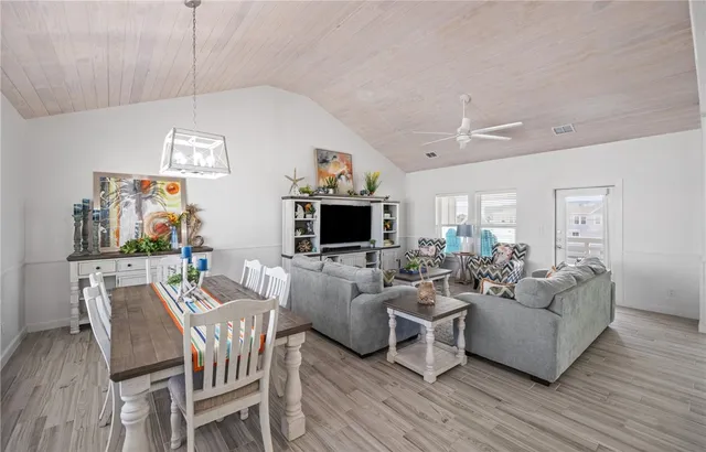 a living room with furniture a flat screen tv and kitchen view