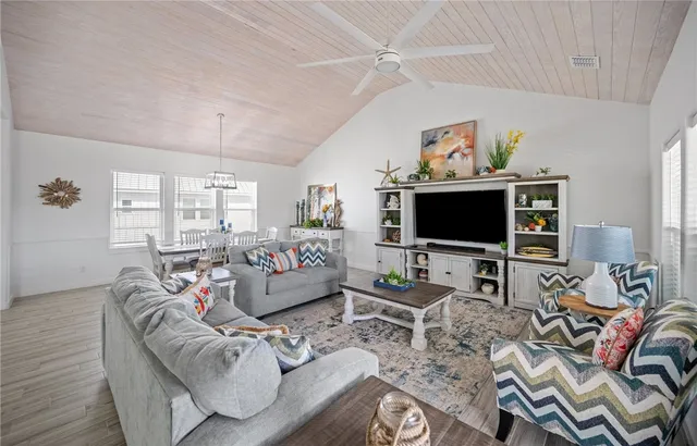 a living room with furniture a flat screen tv and a window
