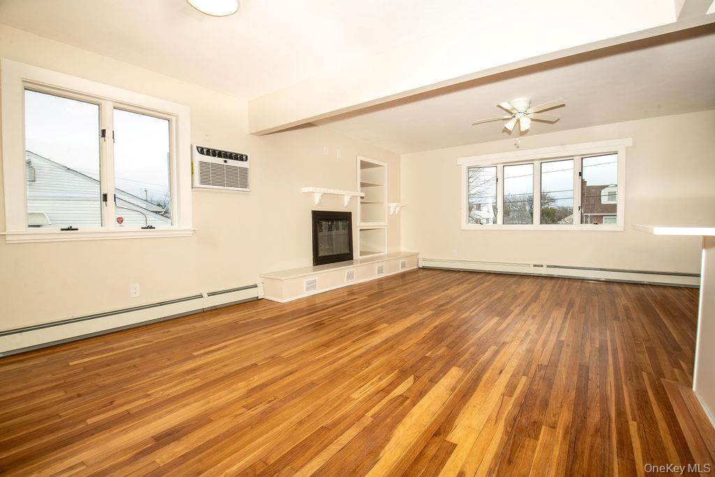 15 East Clearwater Road Lindenhurst, NY 11757 - Photo 15 of 25 an empty room with wooden floor and windows