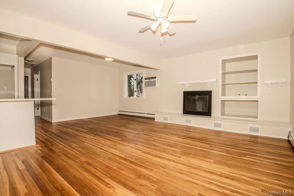 15 East Clearwater Road Lindenhurst, NY 11757 - Photo 16 of 25 a view of empty room with wooden floor and fireplace