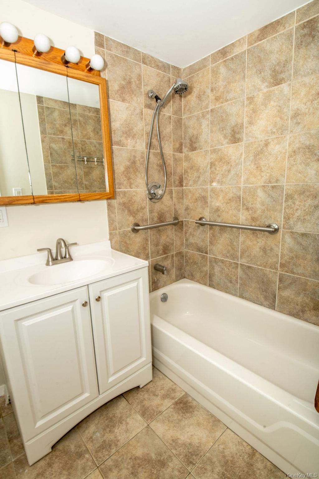 15 East Clearwater Road Lindenhurst, NY 11757 - Photo 20 of 25 a bathroom with a sink a mirror and a bathtub