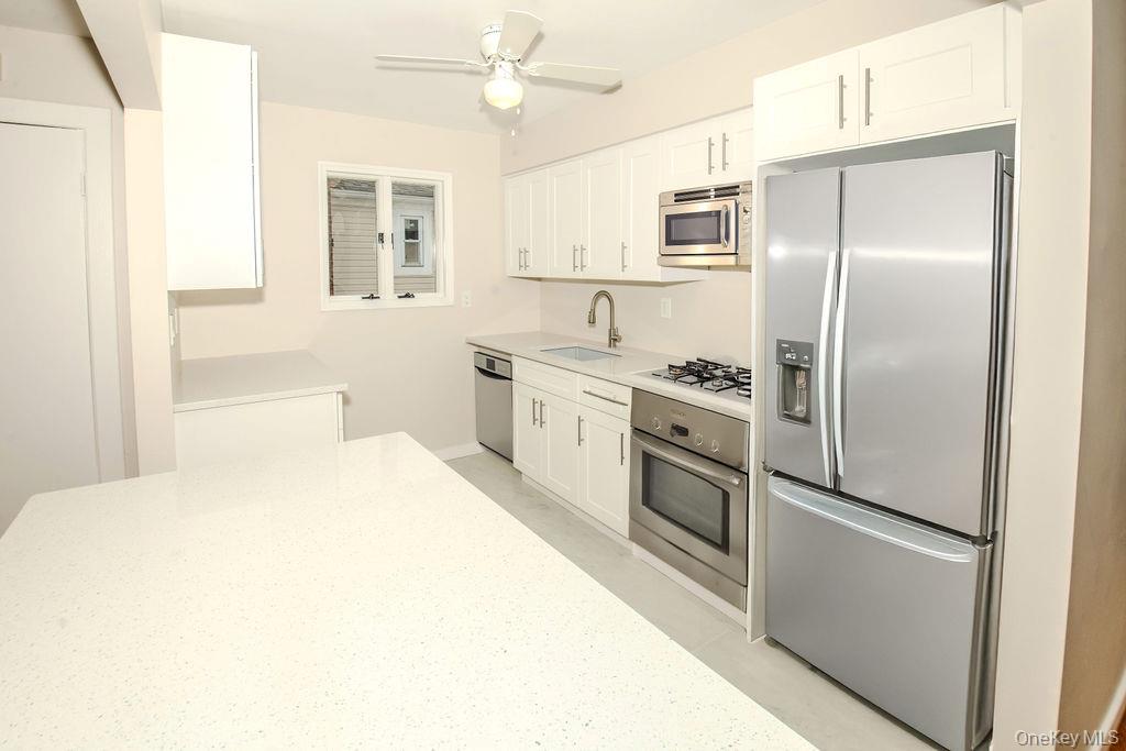 15 East Clearwater Road Lindenhurst, NY 11757 - Photo 2 of 25 a kitchen with stainless steel appliances a refrigerator sink and microwave